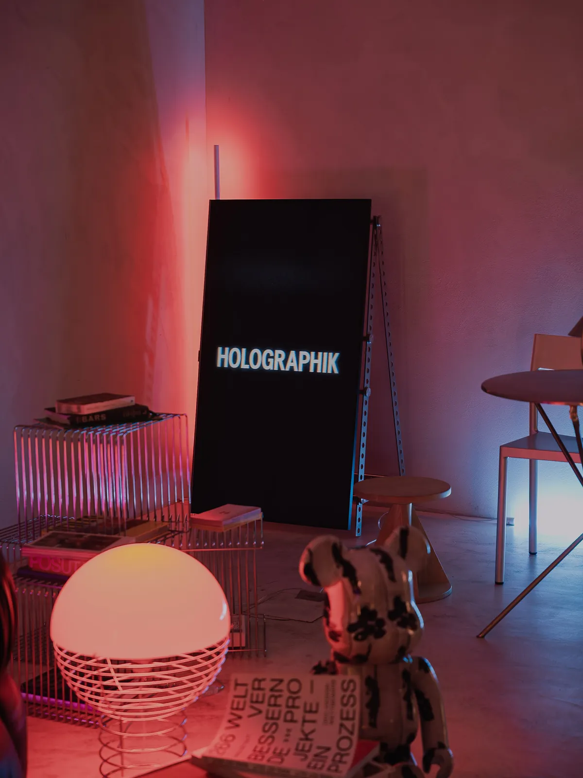 The set before the doors opened: the Holographik sign, a Panthella lamp and a Bearbrick on the floor