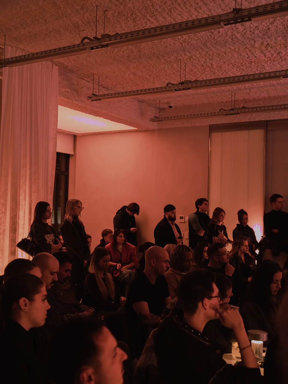 The audience under the pink light at Fashion Talks