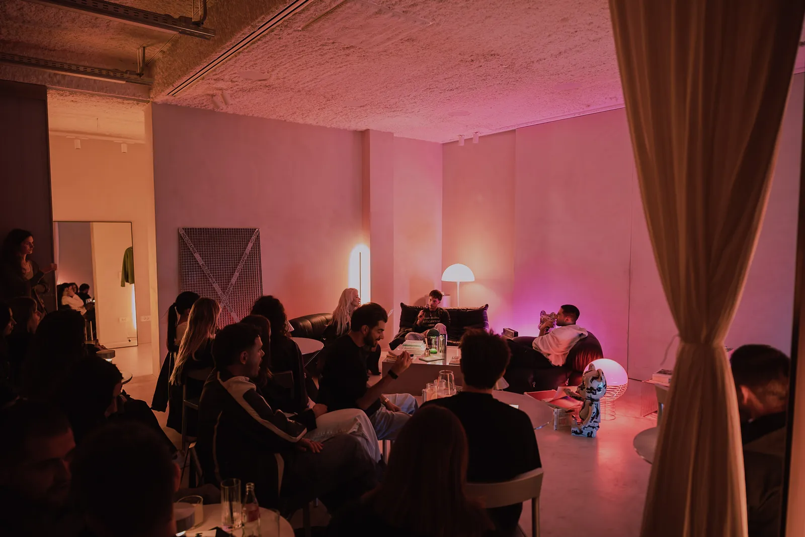 The floor from the side, the stage lit pink and the tables full