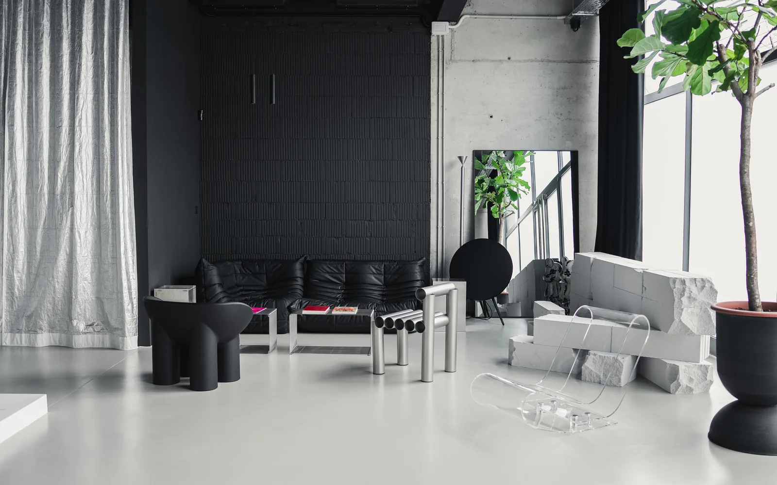 Togo sofa, Roly Poly armchair, a tubular steel chair and an acrylic lounger in the Holographik Space showroom